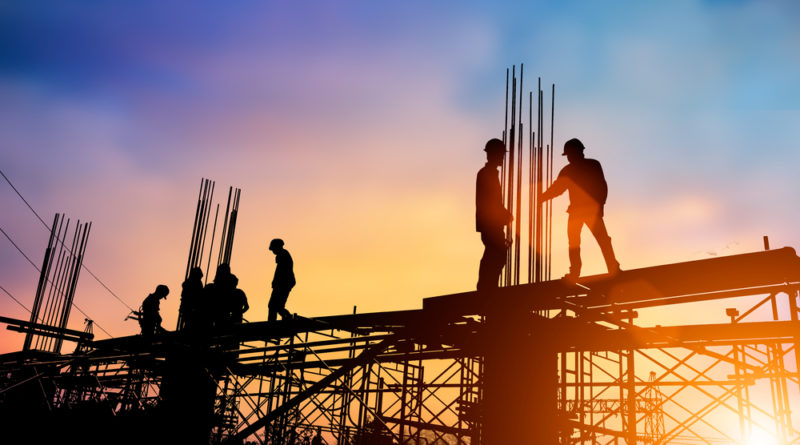 construction workers on scaffolding during sunset